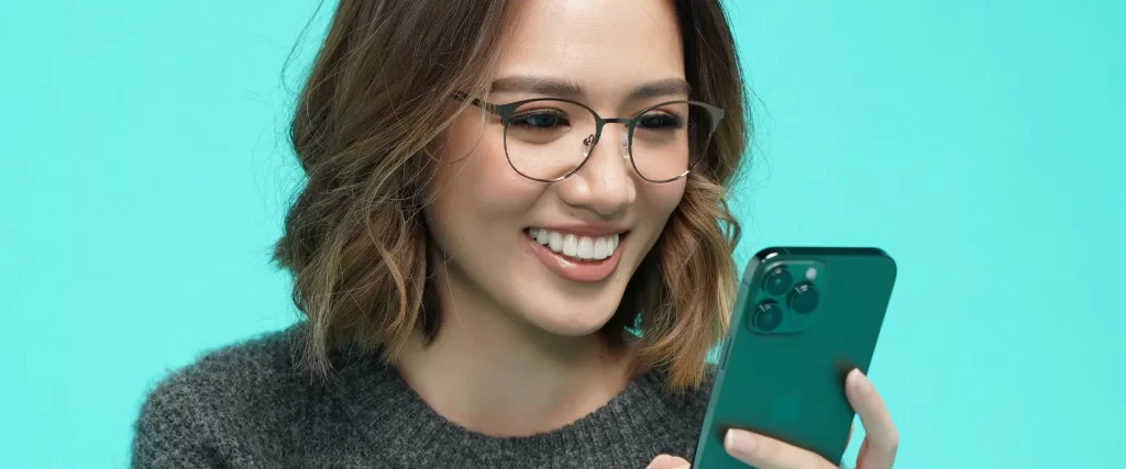 A woman with eyeglasses using her cellphone.