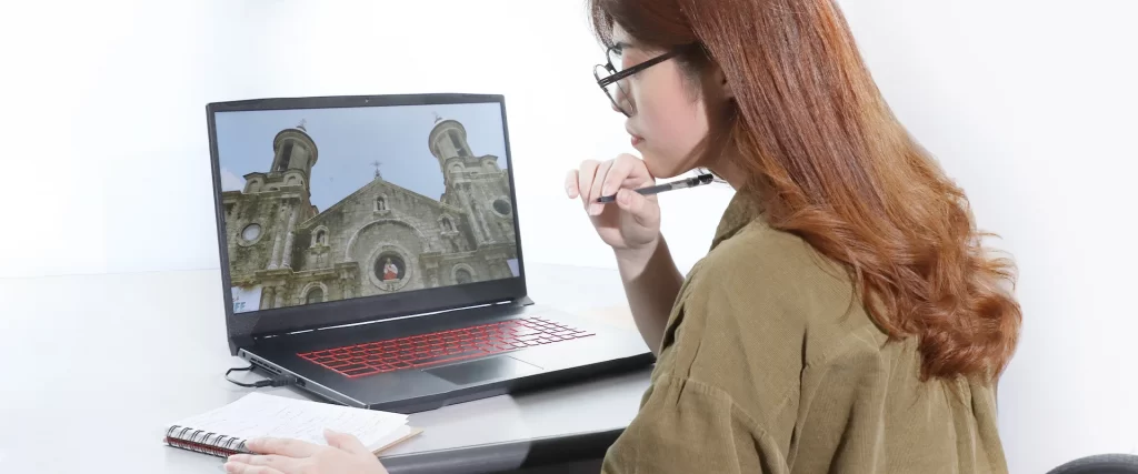 A model researching on a laptop (show laptop screen - a photo of San Sebastian Cathedral in Bacolod City)