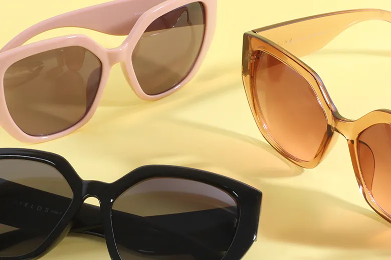 Three pairs of sunglasses on a brown background
